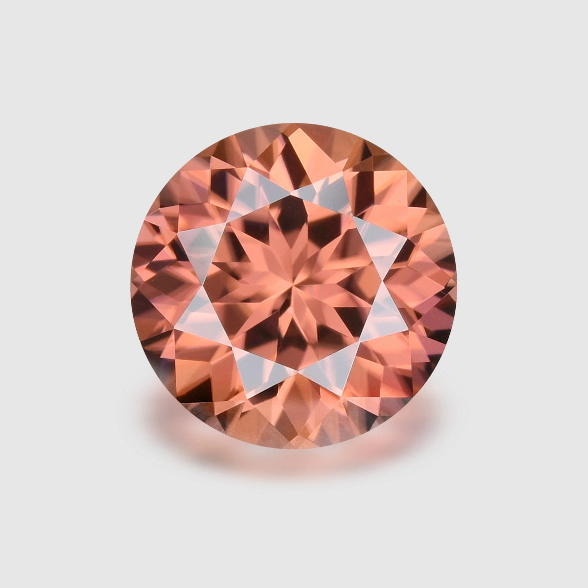Loupe Clean, precision round-cut Imperial garnet.