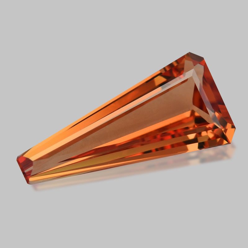 Custom tapered-cut orangey pink Padparadscha sapphire.